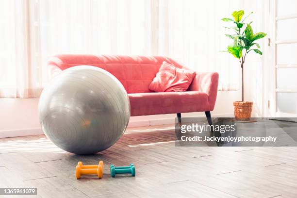 yoga mat, weights and yoga ball on floor at home in living room - yoga ball work 個照片及圖片檔