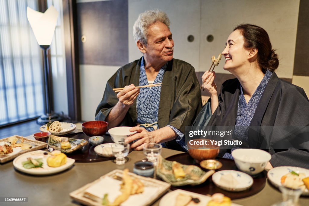 Hispanic couple stays at a machiya hotel in Kyoto and enjoys Japanese food.