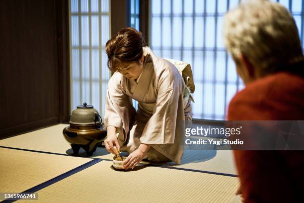 couple experiences a tea ceremony in kyoto during a travel visit. - feierliche veranstaltung stock-fotos und bilder