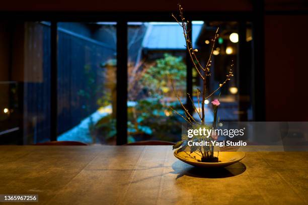 japanese flower arrangements displayed in a renovated machiya hotel. - dining table stock pictures, royalty-free photos & images