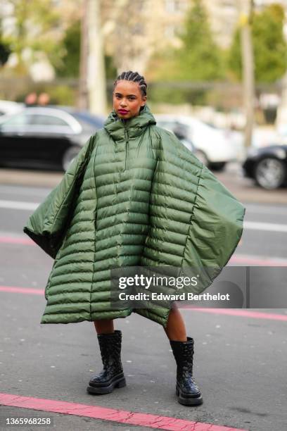 Paola Locatelli wears a green long oversized puffer winter coat worn as a dress, black leather military boots, outside Rains , during Paris Fashion...