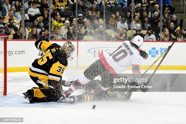 Evan Rodrigues of the Pittsburgh Penguins slides underneath Alex Formenton of the Ottawa Senators and is given a penalty for holding on the breakaway...