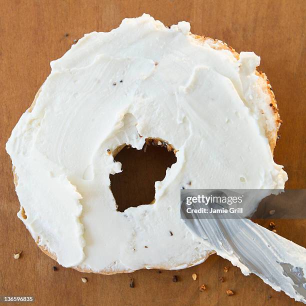 close up of bagel with cream cheese - spreading imagens e fotografias de stock