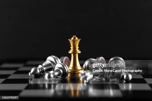 golden queen chess amongst fallen silver chess pieces - schachfigur stock-fotos und bilder