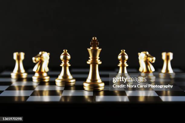 golden chess piece line up black background - chess piece stock pictures, royalty-free photos & images