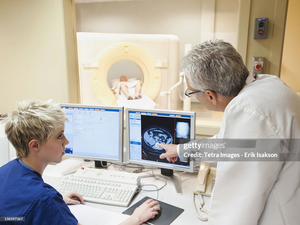 USA, Utah, Ogden, Doctor and nurse looking at CAT scan of patient's brain