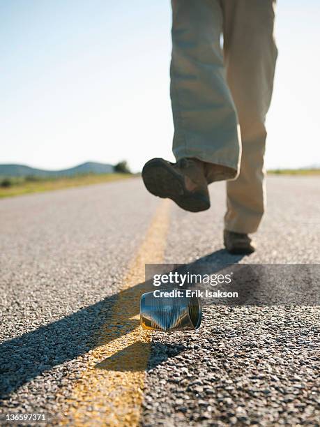 usa, utah, kanosh, man kicking tin can on otherwise empty road - kicking can stock pictures, royalty-free photos & images