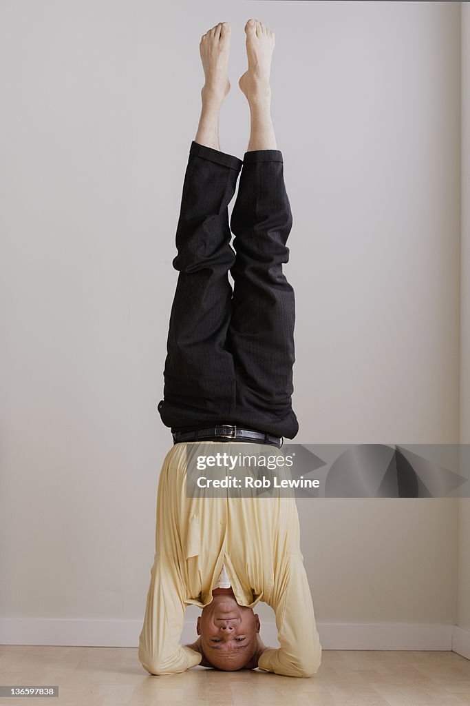 Mature businessman doing headstand