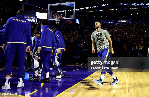 Stephen Curry of the Golden State Warriors runs around his teammates during player introductions before their game against the Detroit Pistons at...