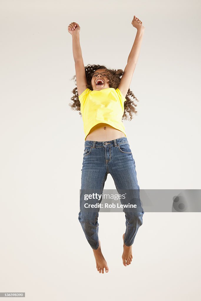 Girl (10-11) jumping, studio shot