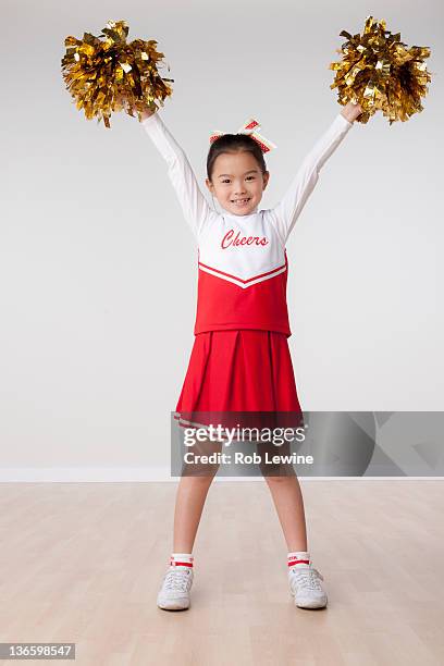 studio portrait of girl (8-9) cheerleading - pom pom stock-fotos und bilder