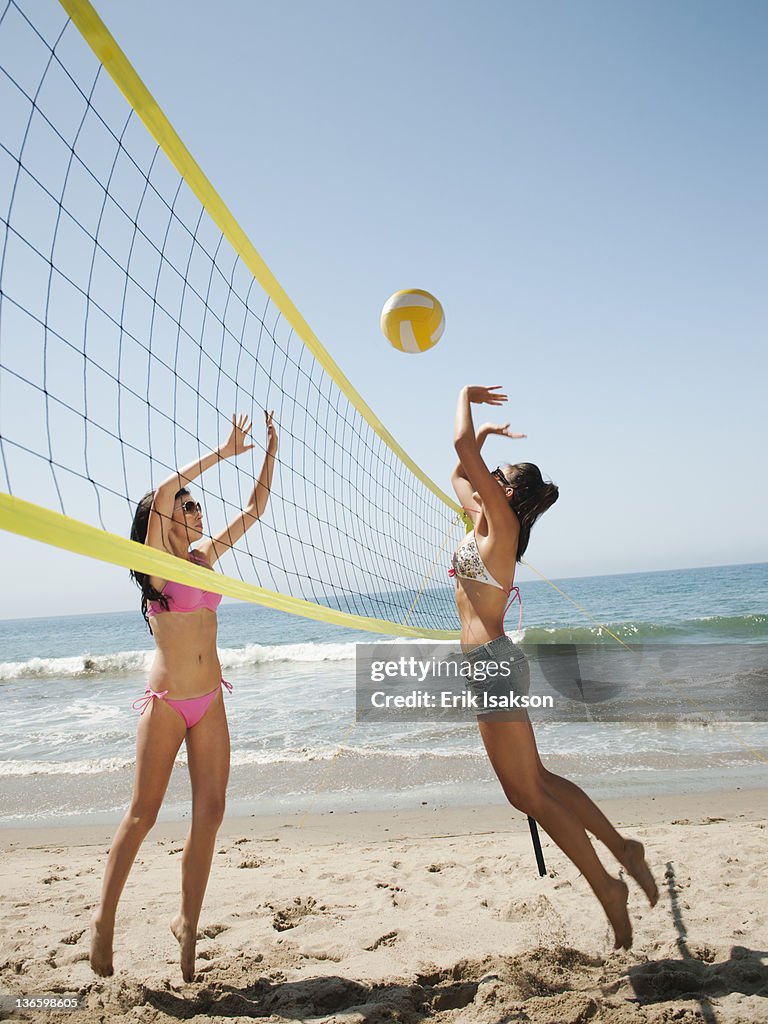 USA, California, Malibu, Two attractive young women playing beach volleyball