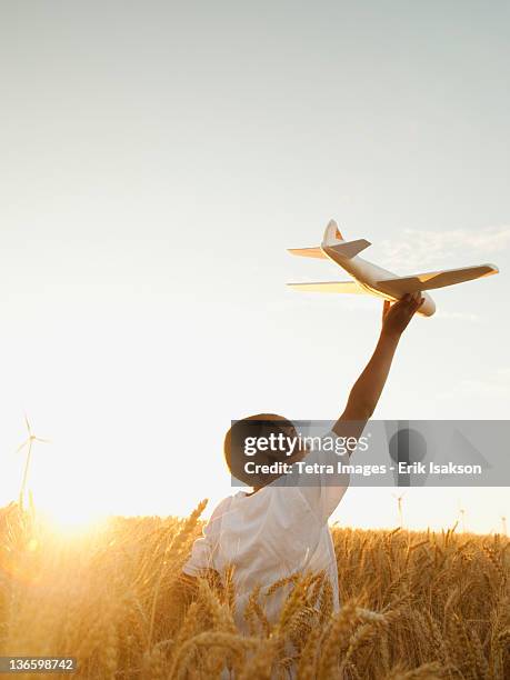 usa, oregon, wasco, boy (10-11) playing with toy aeroplane in wheat field - kind flugzeug stock-fotos und bilder