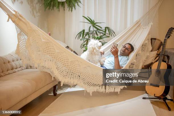 smartphones making life easier at home - inside hammock stock pictures, royalty-free photos & images
