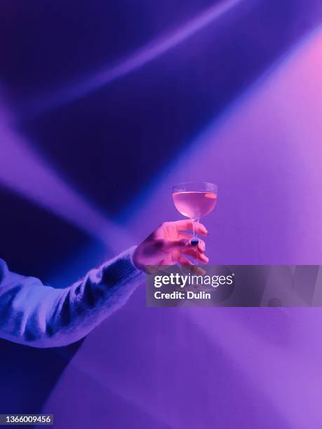 woman's hand holding a cocktail in a nightclub - abstract nightclub stock pictures, royalty-free photos & images