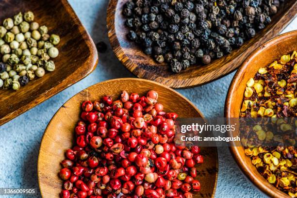 overhead view of bowls of assorted peppercorns - peppar bildbanksfoton och bilder
