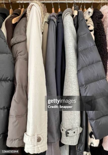 close-up of assorted jackets and coats hanging in a wardrobe - puffer jacket stock pictures, royalty-free photos & images