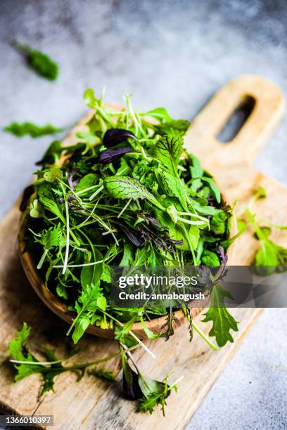 bowl of mixed salad leaves on a chopping board - grönsallad bildbanksfoton och bilder