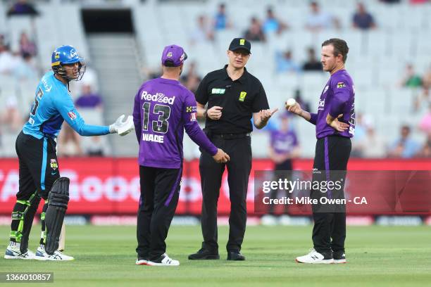 Match umpire Phillip Gillespie is seen talking to Matthew Wade and D'Arcy Short of the Hurricane as Alex Carey of the Strikers looks on during the...