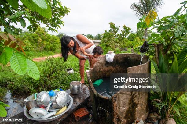 Young mother from the Paiter-Surui tribe washes her child in the early morning at the Paiter-Surui village of Lapetanha in the "7th September Indian...