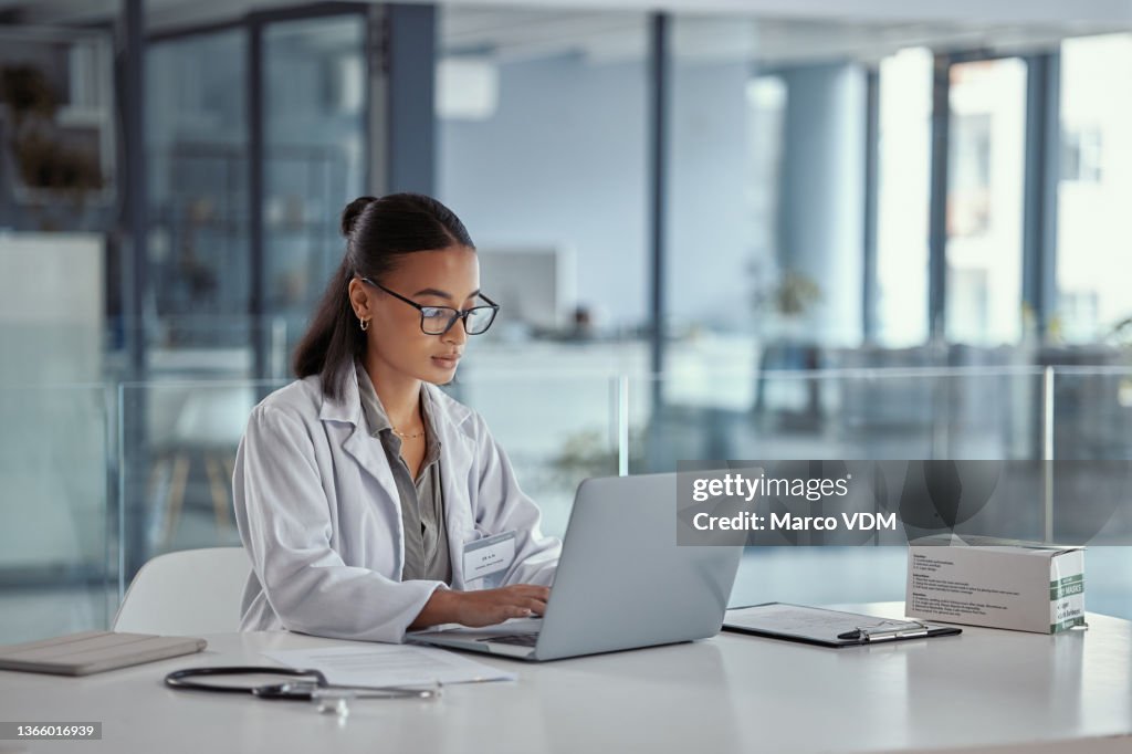 Aufnahme einer jungen Ärztin mit einem Laptop bei der Arbeit