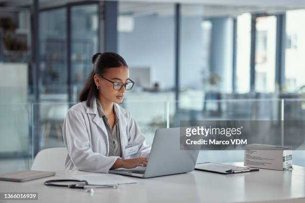 shot of a young female doctor using a laptop at work - 報告 文件 個照片及圖片檔