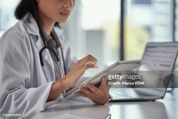 shot of a young female doctor using a digital tablet at work - medical history stock pictures, royalty-free photos & images