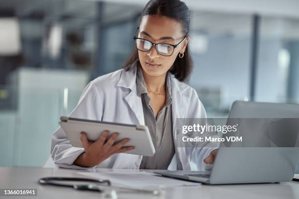foto de una joven doctora usando una tableta digital en el trabajo - laboratory coat fotografías e imágenes de stock