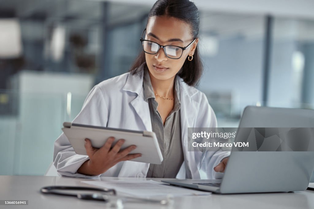 Shot of a young female doctor using a digital tablet at work