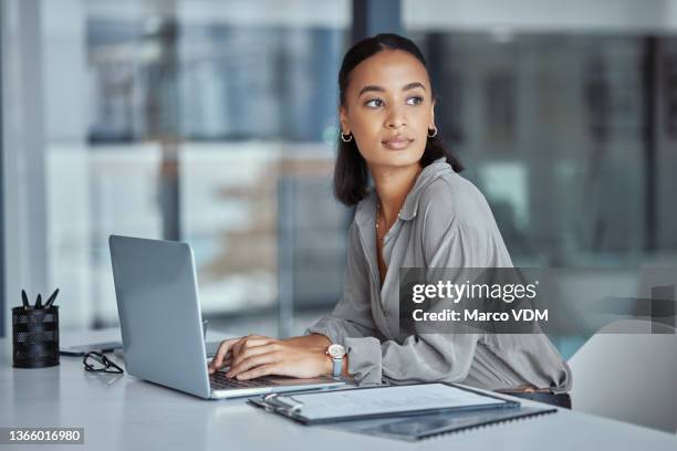 shot of a young businesswoman using a laptop in an office at work - woman day dreaming stockfoto's en -beelden