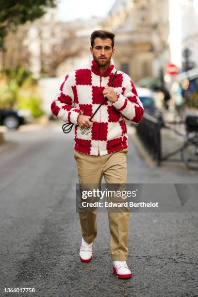 Guest wears a red and white checkered print pattern fluffy zipper / high neck jacket from Louis Vuitton, a crossbody bag from Louis Vuitton, beige...