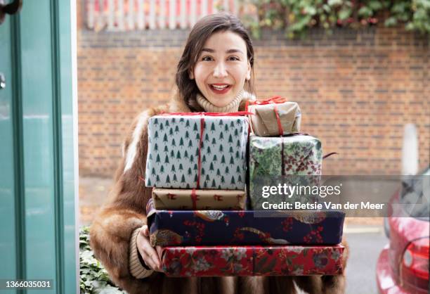 visitor is standing at front door, carrying gifts. - christmas guest stock pictures, royalty-free photos & images