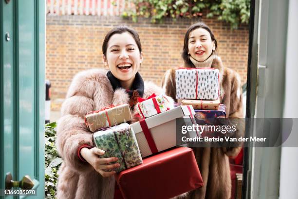 friends visiting, carrying gifts. - holiday arrival stock pictures, royalty-free photos & images