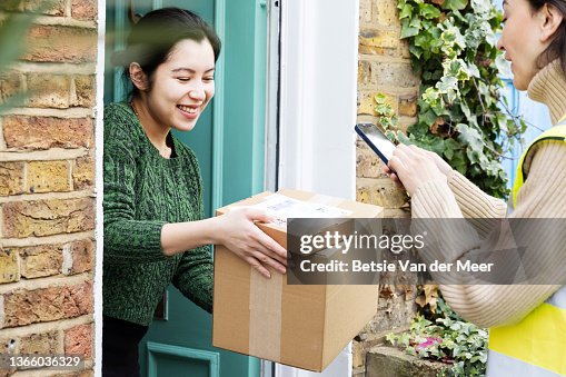 Courier photographs parcels delivered to door, held by recipient. Courier photographs parcels delivered to door, held by recipient.