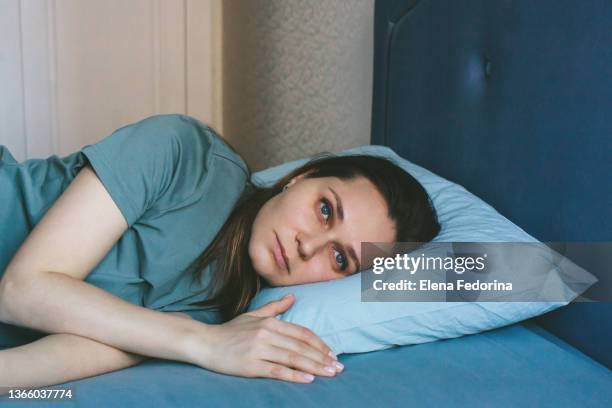 beautiful pensive woman looks out the window. - insomnia stockfoto's en -beelden