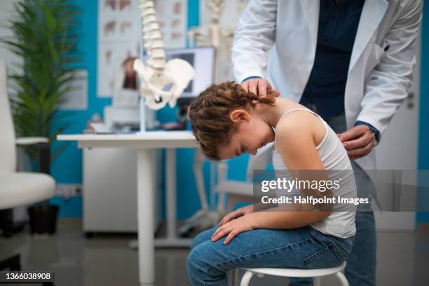 pediatrician doing development medical exam with little girl, checking spine. - human spine fotografías e imágenes de stock