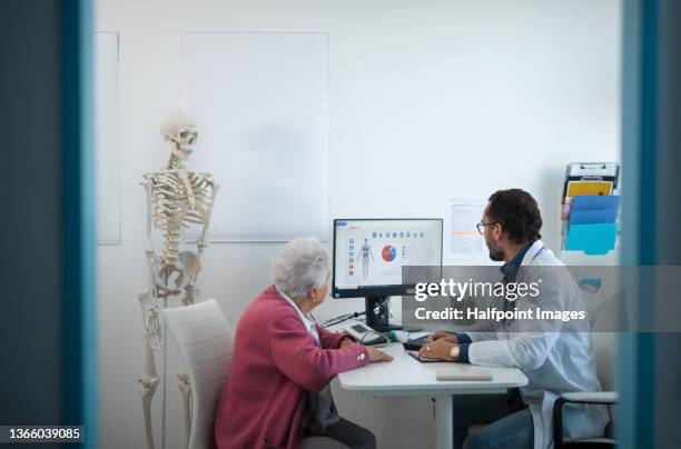 senior woman on consultation with orthopedic doctor in his office. - orthopedic surgeon ストックフォトと画像