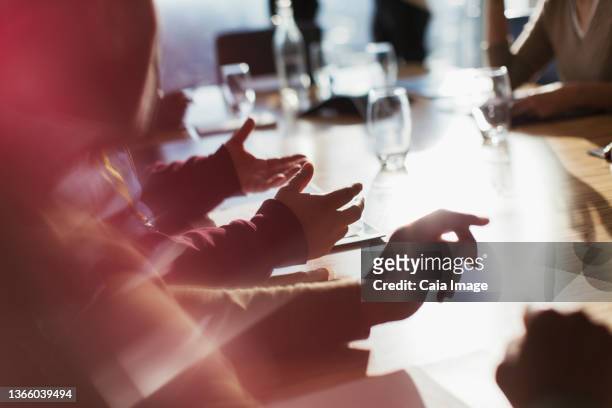 business people gesturing in sunny conference room meeting - boardroom meeting stock pictures, royalty-free photos & images