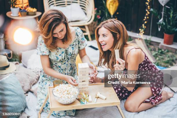 friends having fun while playing board at the backyard. - backyard picnic stockfoto's en -beelden