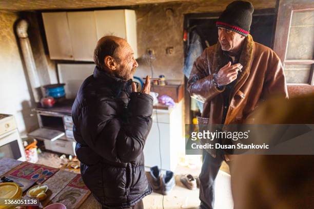 homeless friends, talking and smoking cigarette at the homeless shelter - homeless shelter man stock pictures, royalty-free photos & images
