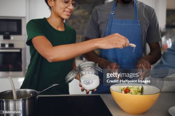 father supervising his teenage kid when preparing food at home. - black cook stock-fotos und bilder