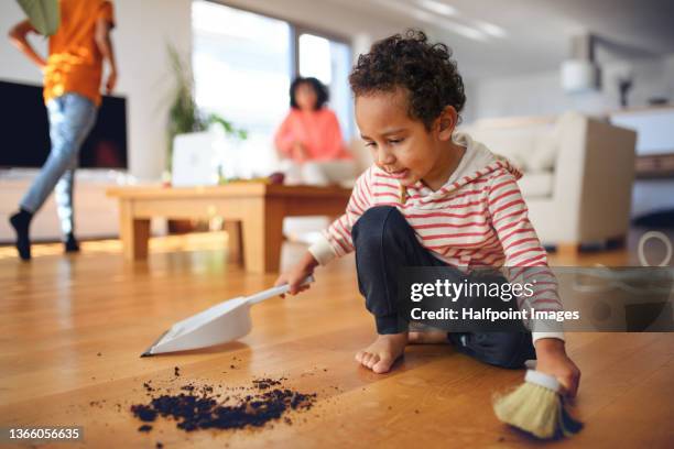 little multiracial boy sweeping dirt at home. - barre class fotografías e imágenes de stock