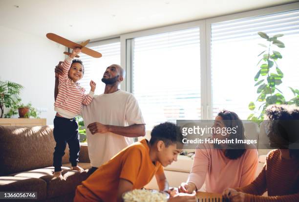 happy multiracial family with three children playing domino at home. - toy airplane stock-fotos und bilder