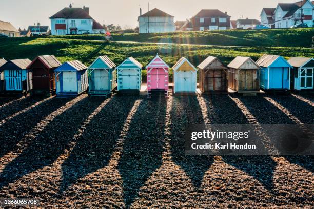 an elevated daytime view of beach huts casting long shadows on the beach - whitstable bildbanksfoton och bilder