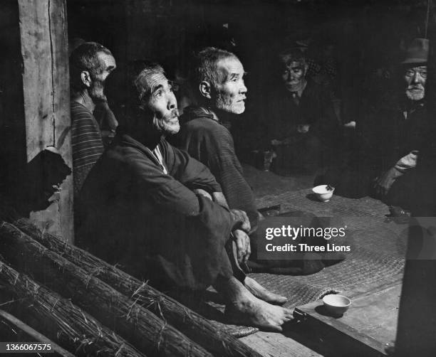 Aged Okinawan civilian refugees wait in the shelter of a refugee centre after being evacuated from their homes to escape the fighting between...