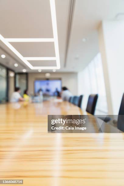 business people at long conference room table - long distance relationship stockfoto's en -beelden