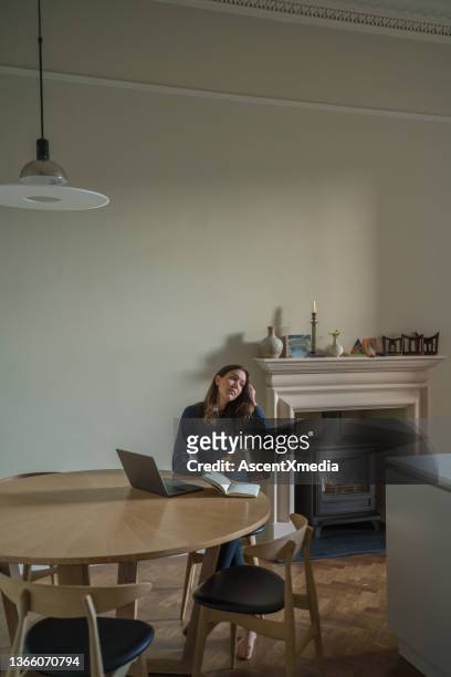 young woman works online, at living room table - stay at home order stock pictures, royalty-free photos & images