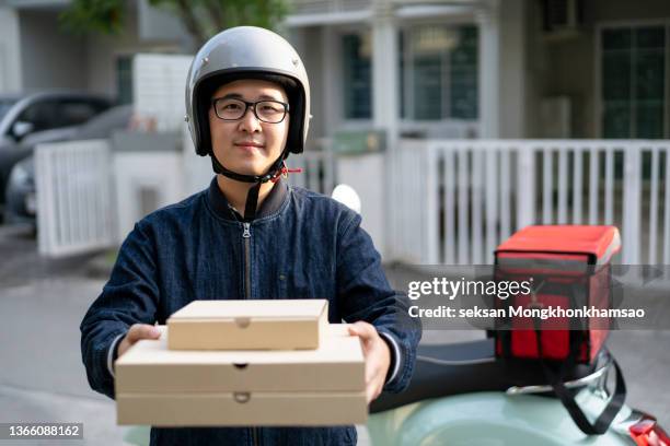 delivery boy bringing pizza - pizza delivery stock pictures, royalty-free photos & images