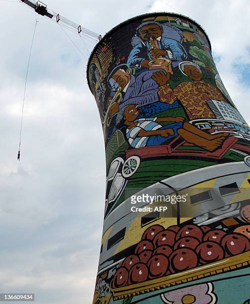 Man performs a bungee jumping from the top of a thermal power plant, closed 13 years ago, in Soweto on December 29, 2011. The cooling tower is about...