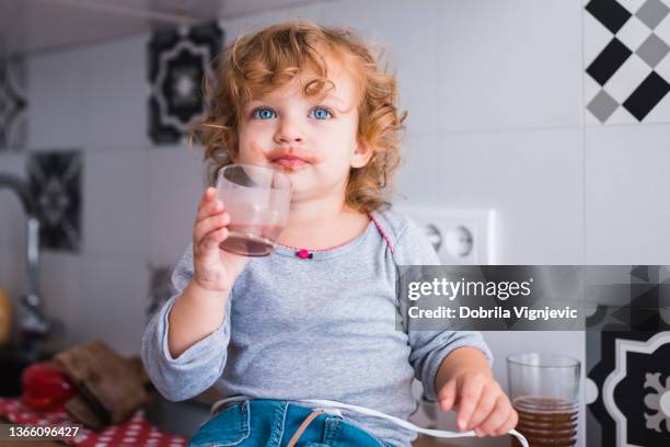 toddler messy all over its face drinking chocolate milk - chocolate face stock pictures, royalty-free photos & images